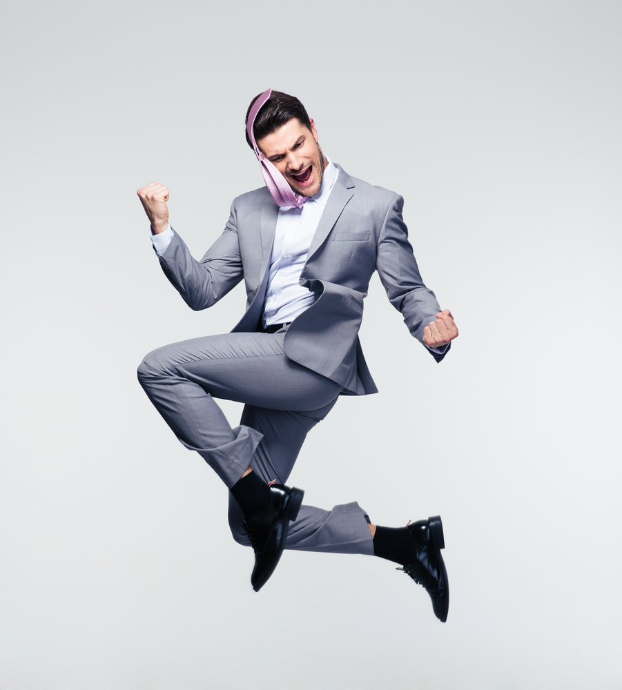 man jumping up in a grey suit