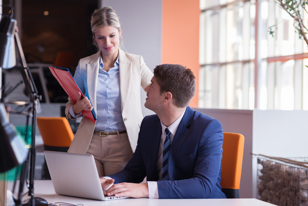 woman and man talking in office